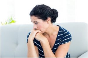 سيدة تنظر إلى الأرض في حزن