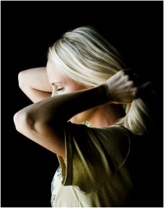 سيدة شقراء تقوم بلف شعرها