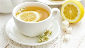 فنجان من منقوع الليمون مع نصف ثمرة ليمون