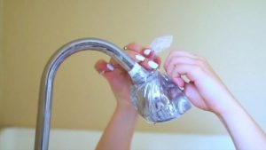 فتاة تقوم بتغليف رأس الدش بكيس