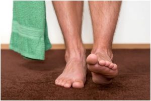 قدمين عاريتين ومنشفة في الحمام