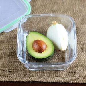 وعاء بلاستيكي به نص حبة أفوكادو ونصف بصلة