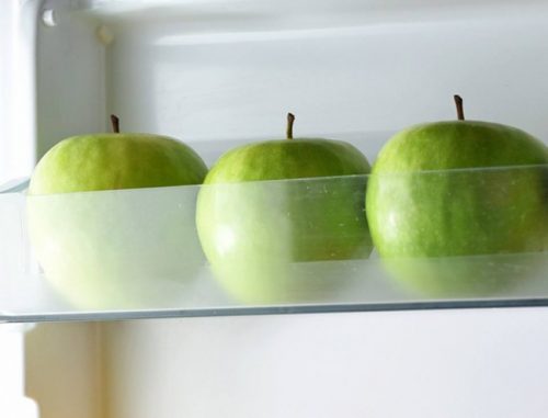 ثلاث حبات تفاح أخضر موضوعة في الثلاجة