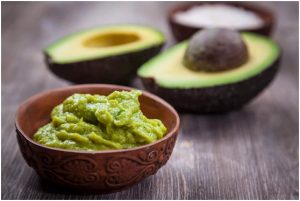 ثمرة أفوكادوا بجوار طبق من الصلصة