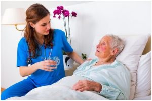 سيدة مسنة تجلس في المشفى وبجوارها ممرضة