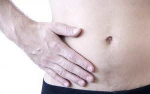 شاب يضع كفه على بطنه من الألم