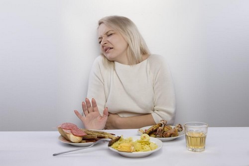 امرأة تعاني من آلام المعدة أثناء الطعام