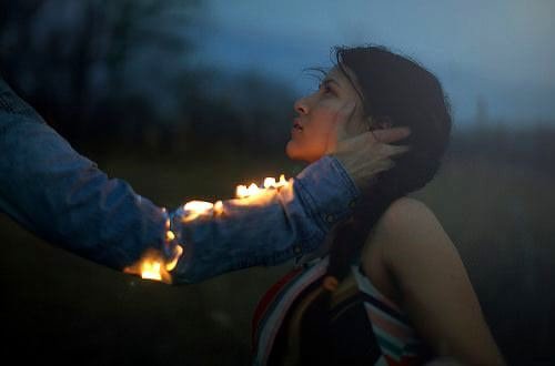 يد رجل تمسك بفتاة وهي تحترق