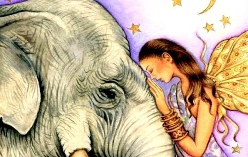 فتاة تضع وجهها على رأس فيل