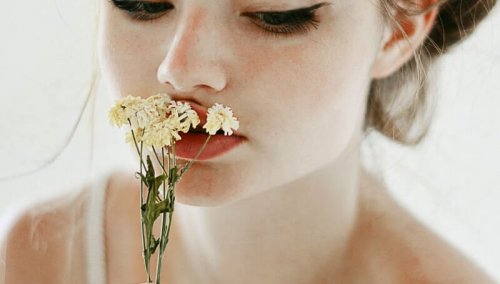 فتاة تضع على فمها الأزهار