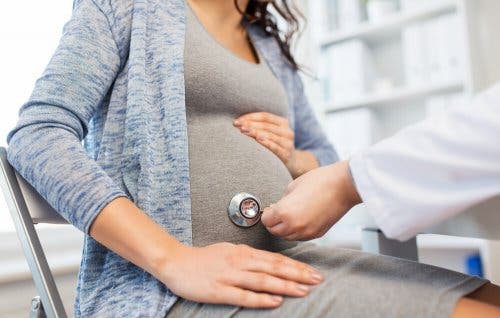 سيدة حامل تفحص نفسها لدى الطبيب من أجل معرفة أسباب آلام البطن